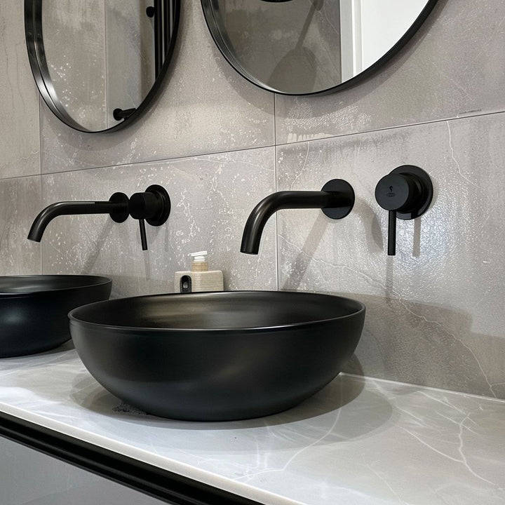 Robinet d’eau mural salle de bain noir mat, style contemporain, installé sur carrelage gris texturé