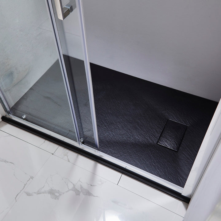 Bac à douche noir installé dans une cabine moderne – base de douche rectangulaire avec surface texturée effet pierre naturelle.