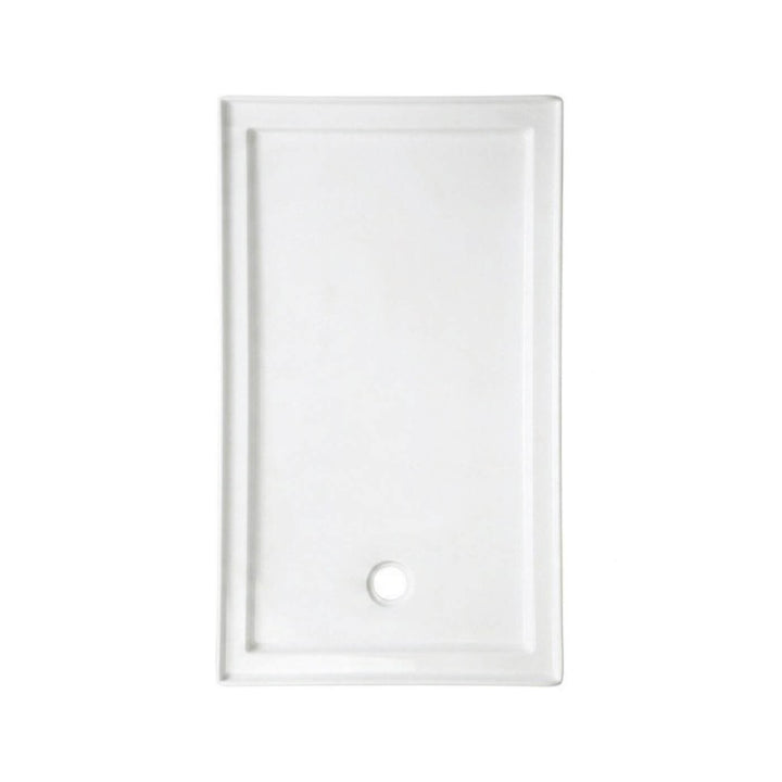 Vue de dessus d'une base de douche en acrylique blanche pour installation en alcôve, montrant le drain décentré.