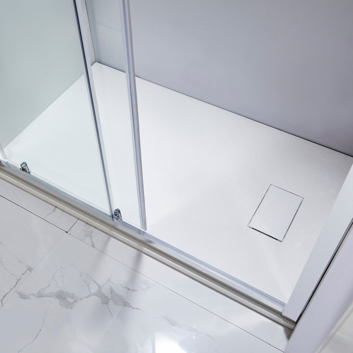 Base de douche en coin blanche avec grille intégrée – installation élégante dans une salle de bain moderne avec paroi vitrée.