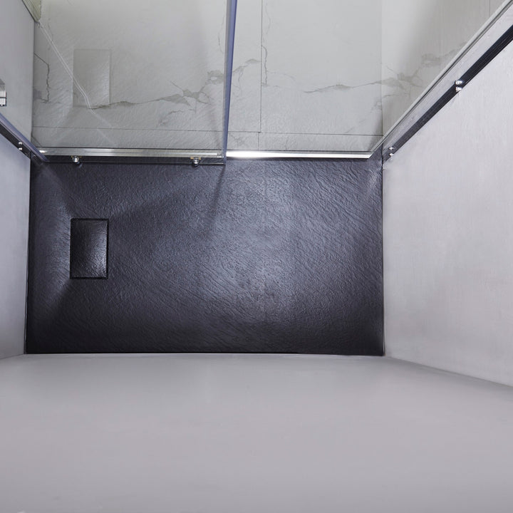 Basse de douche noire installée dans un angle, surface texturée antidérapante – style contemporain pour salle de bain.