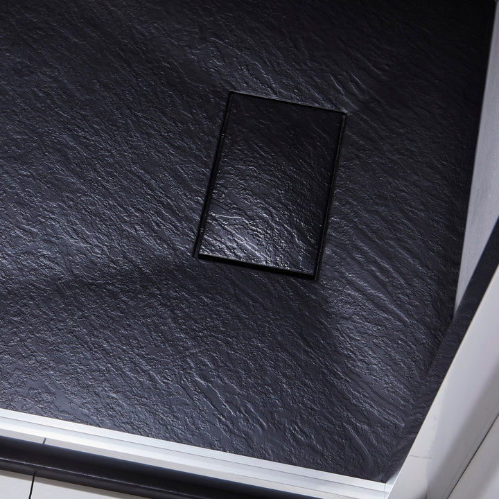 Installation d’une base de douche noire texturée – surface antidérapante effet pierre, receveur moderne et sécurisé.