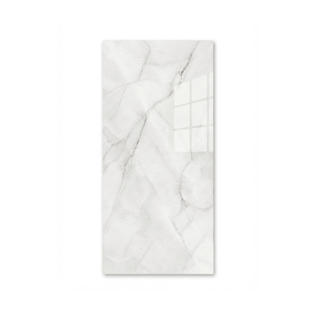 Gros plan d'une tuile de céramique pour douche, grand format rectangulaire, avec un motif de marbre blanc poli et de fines veines grises et dorées.