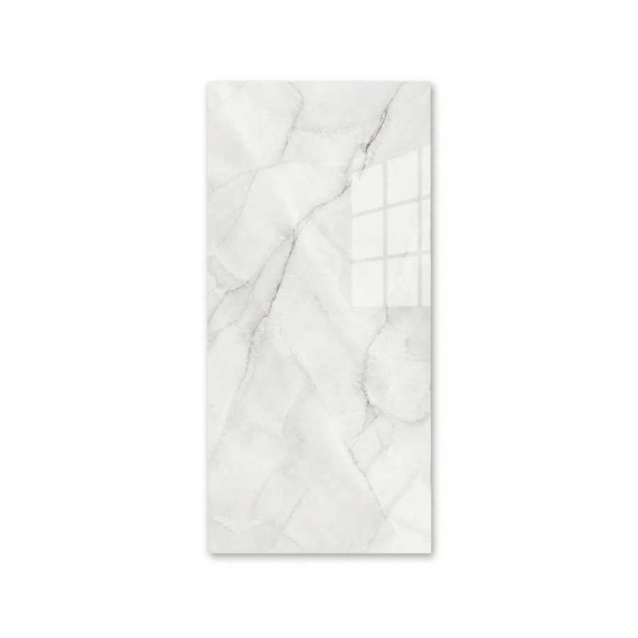 Gros plan d'une tuile de céramique pour douche, grand format rectangulaire, avec un motif de marbre blanc poli et de fines veines grises et dorées.