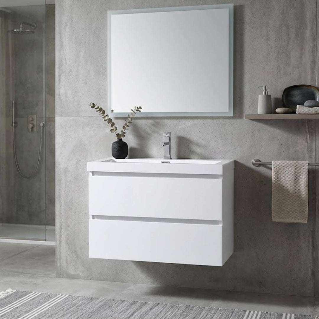 Vue rapprochée d'une vanité de salle de bain blanche de style minimaliste avec un grand miroir rectangulaire et décorations zen.