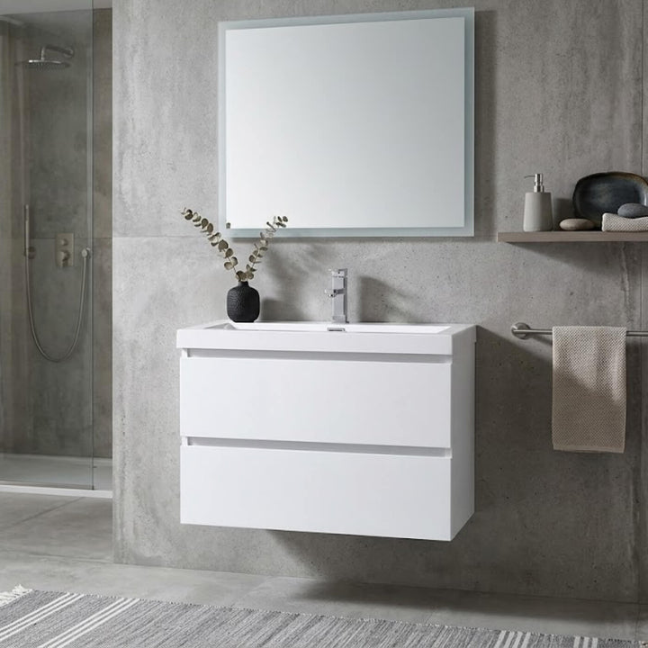 Vue rapprochée d'une vanité de salle de bain blanche de style minimaliste avec un grand miroir rectangulaire et décorations zen.